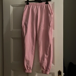 Rosa sweatpants Brandy Melville - Sparsamt använda.  Superskönt med elastiskt band i midjan. Sidofickor Mudd i benen.  28 cm midja 71 cm beninnerlängd. En pytteliten rosa prick på övre låret som ej går bort i tvätten.   Köparen står för frakten. Nypris 355 kr 