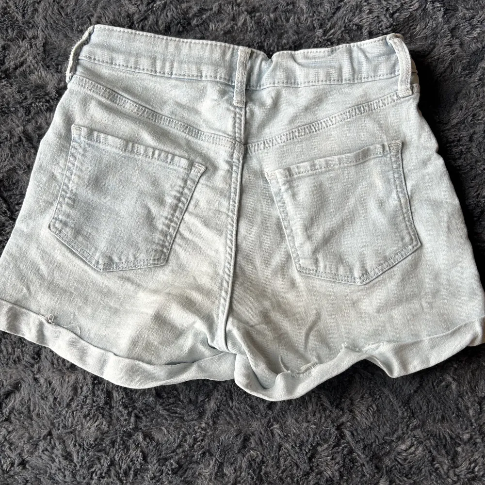 Snygga jeans shorts i ljusblå färg, lite högre i midjan men skulle inte säga att de är så höga. Säljer då de blivit för små, på ena sidan bak där nere vid kanten så har kanten gått upp men tror att man bara kan vika in den och stryka💓. Shorts.