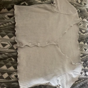 Magtröja topp  - En vitt magtröja använd få tal gånger med knappar vid bröstet 