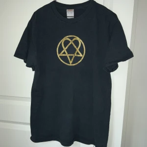 HIM T-shirt  - Från bandet HIM, slitningar i trycket (se bild 3)  därav priser, bomullen är dock fortfarande i mjuk kvaliten så den sitter fint på och har inga noppringar 