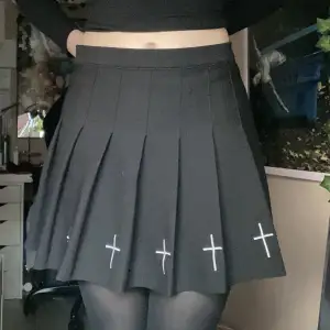 Svart kjol med kors och insydda shorts. Skickligt använd