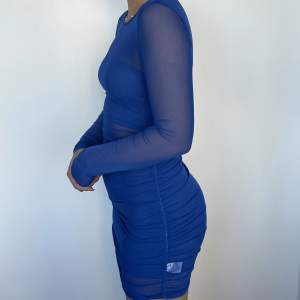 Blå klänning som kommer i tre separata delar; en tubtopp en tubkjol samt en hel meshklänning över. Oanvänd från Shein.