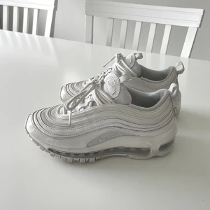 Nike Air Max 97 vit - Ett par vita Nike Air Max 97 i storlek 35.5 Köptes i maj 2023 och nypris är ca 1700kr. Knappt använda och är i väldigt fint skick💕