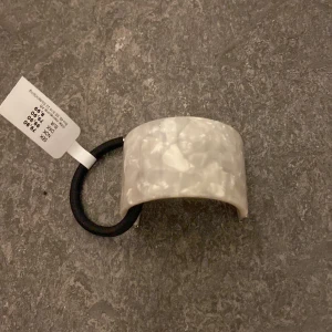 Hårsnodd - Hårsnodd med marmor detalj. Aldrig använd och inköpt på glitter. Originellt kostar 80 kr, jag säljer för 30