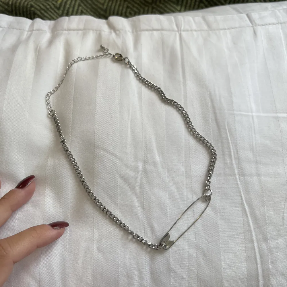 silvrigt halsband med en säkerhetsnål, nästan helt oanvänd. ungefär 48 cm. Accessoarer.