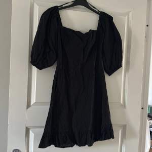En svart broderad klänning från bikbok med puffärm.