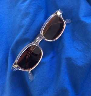 Solglasögon - Solglasögon från Tom Barny. Genomskinlig båge. 