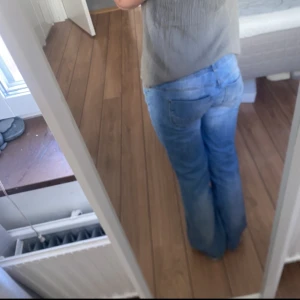 Lågmidjade jeans  - Ljusblå Lågmidjade bootcut jeans. En av knapparna saknas, kan skicka med en extra.