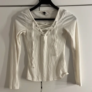 Långärmad tröja  - Genomskinlig, vit, långärmad tröja med knyt band vit överdelen. Tröjan har använts få gånger och är i väldigt bra skick. 