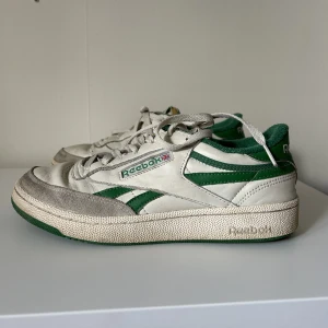 Reebok Club C vintage - Ett par Reebok Club C Vintage med gröna detaljer. I storlek 41. Mycket bra skick men lite smutsiga, det mesta går att tvätta bort. Säljer pga för stora för mig. 