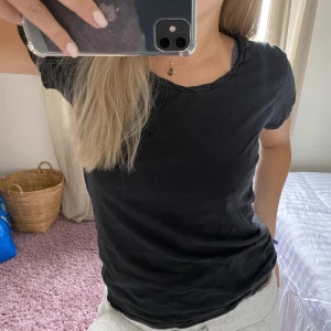 Svart T-shirt med snygg urringning  - Svart T-shirt med snygg vriden urringning, från Contemporary reflections! Passar S-M