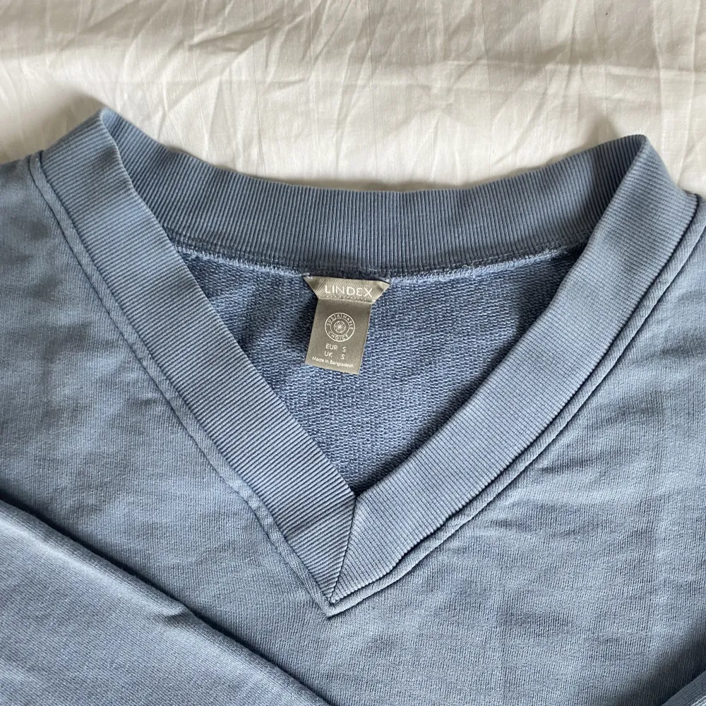 Blå sweatshirt med vringning från Lindex. Tröjor & Koftor.
