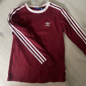 Adidas tröja - En vinröd långärmad adidaströja i tunnare material. Skulle säga att den passar S men mer åt XS än M. Fortfarande i väldigt fin skick. 