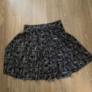 Mönstrad miniskirt i silke - En gammal favoritkjol som tyvärr inte längre används! Kjolen går strax under rumpan på mig som är 160 cm. Jag har sytt in kjolen i midjan men stygnen går enkelt att sprätta upp :)