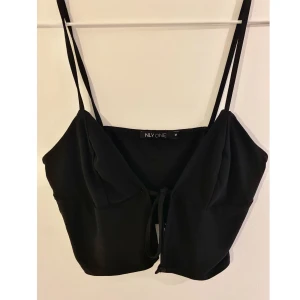 Crop top - Helt oanvänd crop top med snörning från Nelly i storlek M. Väldigt elegant, gör både att klä upp och ner.