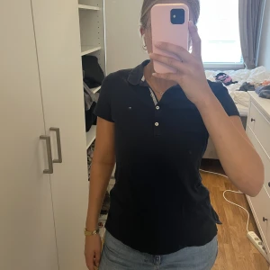 T-shirt Tommy Hilfiger - Mörkblå T-shirt med krage från Tommy Hilfiger.  