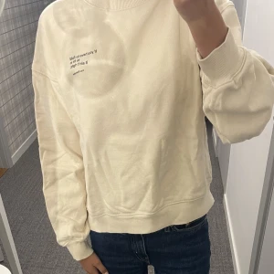 Sweatshirt - Beige sweatshirt från HM i storlek Xs. Den är i fint skick och har ett fint citat.