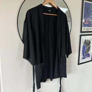 Kavaj i tyg - Svart kavaj i tyg med snörning i midjan. Oversize modell. 