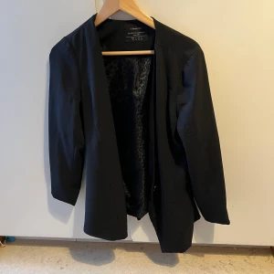 Svart kavaj - Enkel svart kavaj med leopardmönster på insidan.