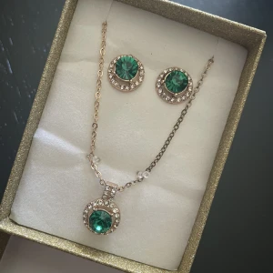 Örhängen med ett halsband  - Helt nya och oanvända örhängen med halsbandet med grön sten (oäkta). 