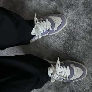 Axel Arigato sneakers - Snygga Axel Arigato sneakers i vitt och lilla. Begränsat använda, visst slitage förekommer men välbehållna. 