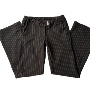 Lågmidjade kostym byxor  - Supersöta randiga kostymbyxor. De är lågmidjade och raka i modellen. Storlek 25 i midjan <3 Midjemåttet är 70cm och innerbenslängden är 72 cm