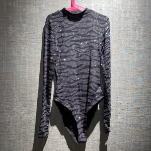 Body | HM - En jättefin glittrig body från HM. Oanvänd. I storlek XS. Tyget är lite genomskinligt. Skriv privat för mer info och bilder.