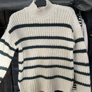 Beige/vit stickad tröja med mörkgröna ränder från vero moda 🤍Använd fåtal gånger så i bra skick :) Så mysig nu till hösten och vintern!!