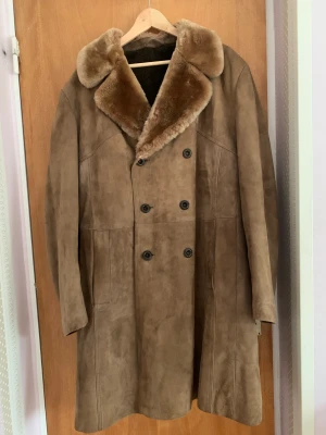 Beige/brun kappa i mocka - Fin oversized vintage varm kappa av äkta mocka med foder av fuskpäls. Från märket Albackens. Rätt stor på mig som vanligtvis bär xs/s så hade nog pssat m/l eller större bättre. Pris kan diskuteras. 