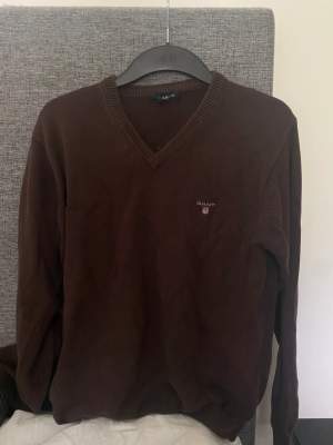 En brun, v-ringad Gant-tröja i storlek S. 