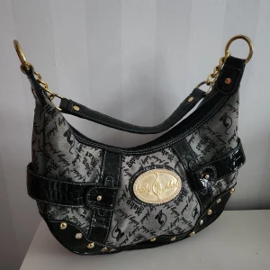 Baby Phat Handväska - En jättefin och sällsynt BabyPhat handväska från 2000 talet! Nypris var runt 1400 kr. Priset kan diskuteras! Skicka jättegärna meddelande ifall du har några frågor