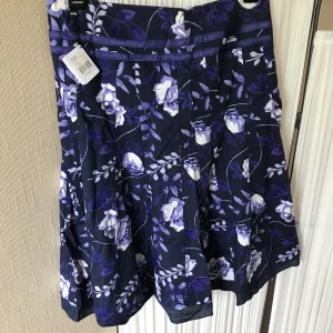 Blommig lila midikjol - Aldrig använd, hämtas i Huddinge. 