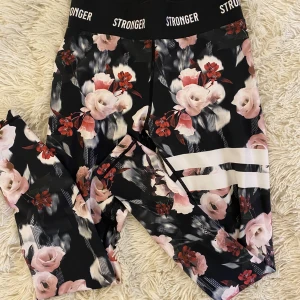 Stronger träningstights - Jättefina aldrig använda tights från stronger. Svarta med rosa blommor. Kontakta mig vid intresse💕köpta för cirka 600 kr 