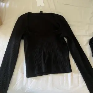 Helt oanvänd svart långärmad tröja med en u-ringning med prislappen kvar. Säljer pga för liten. Skick 10/10. 100kr exklusive frakt.
