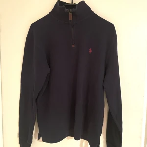 Polo Ralph Lauren Half Zip-Up - Säljer nu min Polo Ralph lauren tröja då den inte passar och har aldrig använt, ny pris 2100kr. Lägre pris då jag vill ha sålt! Storlek är XS men passar även S. Den är ej blå utan mer åt de mörkare hållet. Skriv om ni har frågor eller vill ha mer bilder!