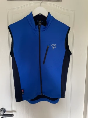 Skidväst - En blå, varm men smidig längdskidväst. Använd sparsamt och i väldigt fint skick.