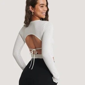 Ribbat topp med öppen rygg  - Vit ribbad topp med öppen rygg i storlek S. Använd någon enstaka gång bara och är i toppskick, ingenting att anmärka på. 94% polyester/6% elastan. Säljes för 250kr + frakt. 