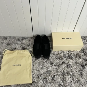 Arigato skor - Säljer dessa snygga Axel Arigato skor utan knytsnören. Skicket är bra, inga skador elr fläckar. Kvitto, box och påse med medföljer vid ett köp. Var inte blyg för att fråga.