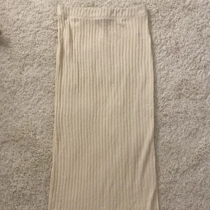 Långkjol - Jättefin beige kjol med slits som går ner till anklarna ungefär! Använd 2-3 gånger endast. Den är i lite frottématerial! Nypris 399.