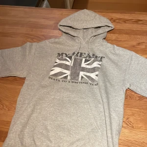 Grå Grish hoodie med tryck - Säljer en grå hoodie med ett stort brittiskt flaggtryck, Helt oanvänd passade inte mig, lite för liten jag är 1,80.Den har en klassisk huva med dragsko och långa ärmar.