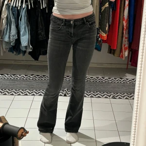 Svarta lowaist bootcut jeans - Snygga svarta lowwaist bootcut jeans med hög midja från zara. Perfekta för en stilren look. Den har en liten slitning på innersidan av midjan men inget som märks på(fråga om bild).