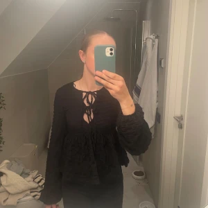 Svart blus med knytning - Fin blus som man kan knyta som man vill, skönt och luftigt material. Aldrig använd bara provad. 
