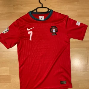 Portugal hemma Ronaldo  - Säljer en röd Portugal fotbollströja från Nike med nummer 7 och namn på baksidan. Tröjan har korta ärmar och ett emblem på bröstet. Nästan helt oanvänd och passar både s och m.
