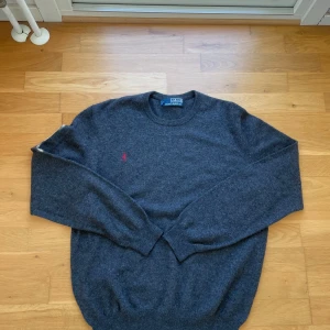 Ralph Lauren Sweatshirt  - Mörkgrå sweatshirt från Polo Ralph Lauren i storlek M. Endast använd 4–5 gånger och fortfarande i mycket fint skick. Bekväm och lättmatchad tröja med stilren design – perfekt för både vardag och avslappnade dagar.