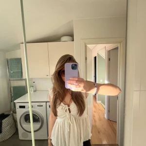 Vit topp  - Säljer en söt vit topp med knytning framtill och volangdetaljer. Toppen har en luftig passform och passar perfekt nu till sommaren. 