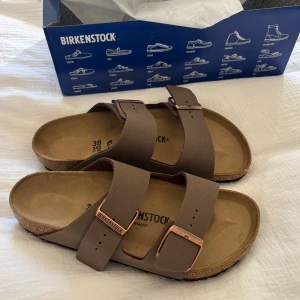 Bruna sandaler från Birkenstock - Supersnygga sprillans nya Birkenstock, säljer då dem inte passade mig i bredden. Strl 38, bredd normal i färgen Mocha, modell Arizona Birko-Flor.