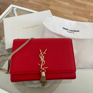 Märkesväska - Väska från Yves Saint Laurent. I nyskick förutom ett litet märke (se bild 5), men inget som syns vid normal användning. Priset är på grund av det lilla märket och inget äkthetsbevis, då nypris ligger på cirka 11 000kr.