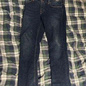 Mörkblå jeans från Nudie Jeans - Säljer ett par snygga mörkblå jeans från Nudie Jeans.
