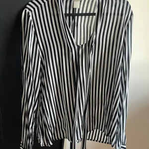 Skjorta/blus - En fin blus med snören som kan knytas bakom nacken eller lite hur man själv vill. 