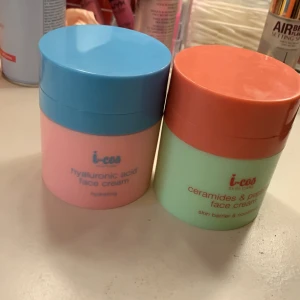 Ansiktskrämer från i-cos - Två ansiktskrämer från i-cos. En med hyaluronsyra i en rosa och blå burk för återfuktning, och en med ceramider och persika i en grön och orange burk för hudbarriär och återhämtning. Båda burkarna innehåller ungefär 50 ml kräm. Den gröna kostar 40 och den rosa 50.